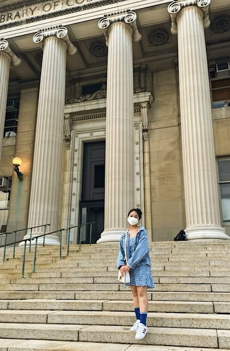 caption: Khanh Doan, a first year student at Columbia University, poses on the steps of Columbia Library at in New York City in August 2021.
