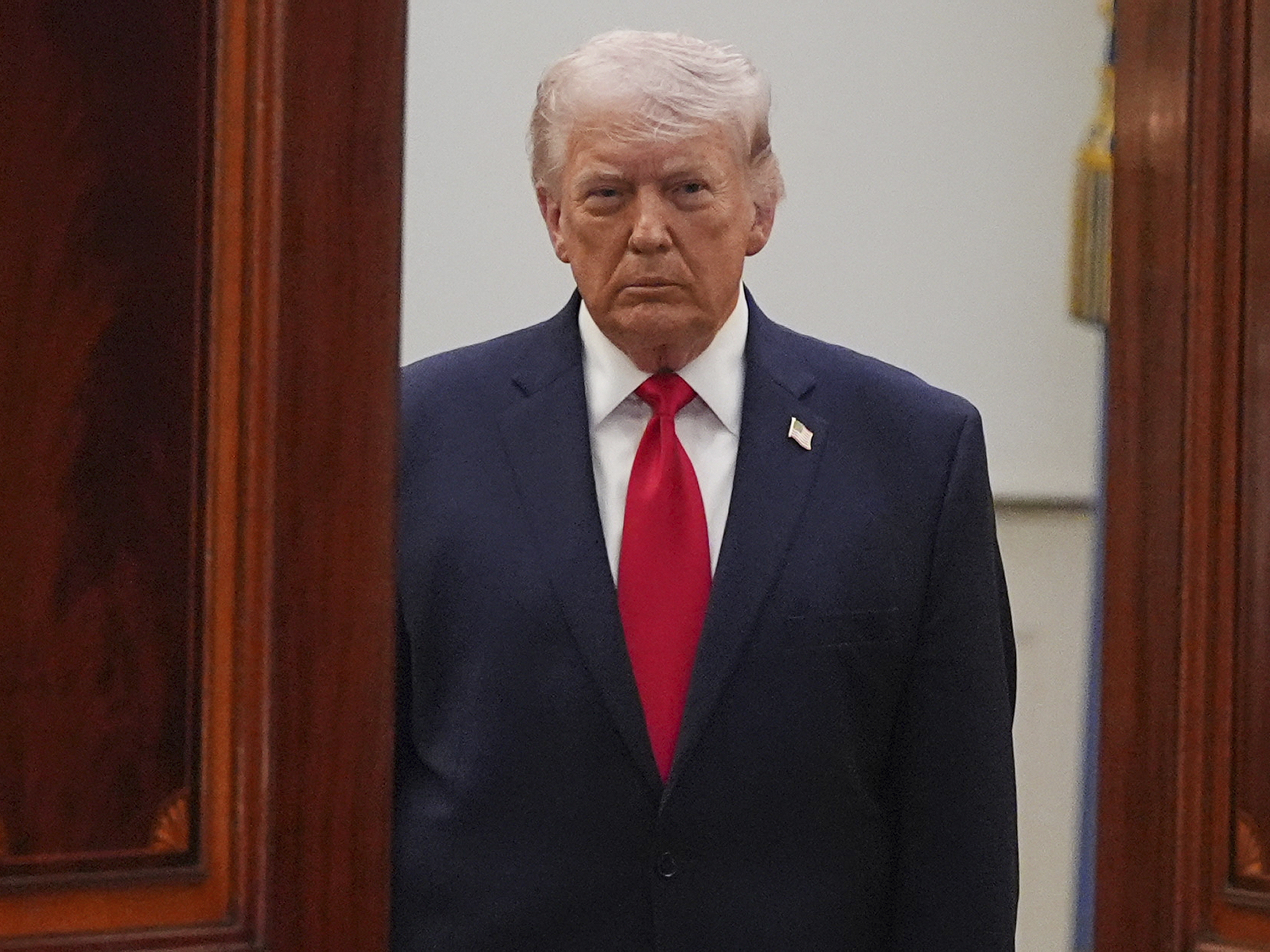 caption: President Donald Trump arrives from the Blue Room to speak about the Iran war from the Cross Hall of the White House on April 1.