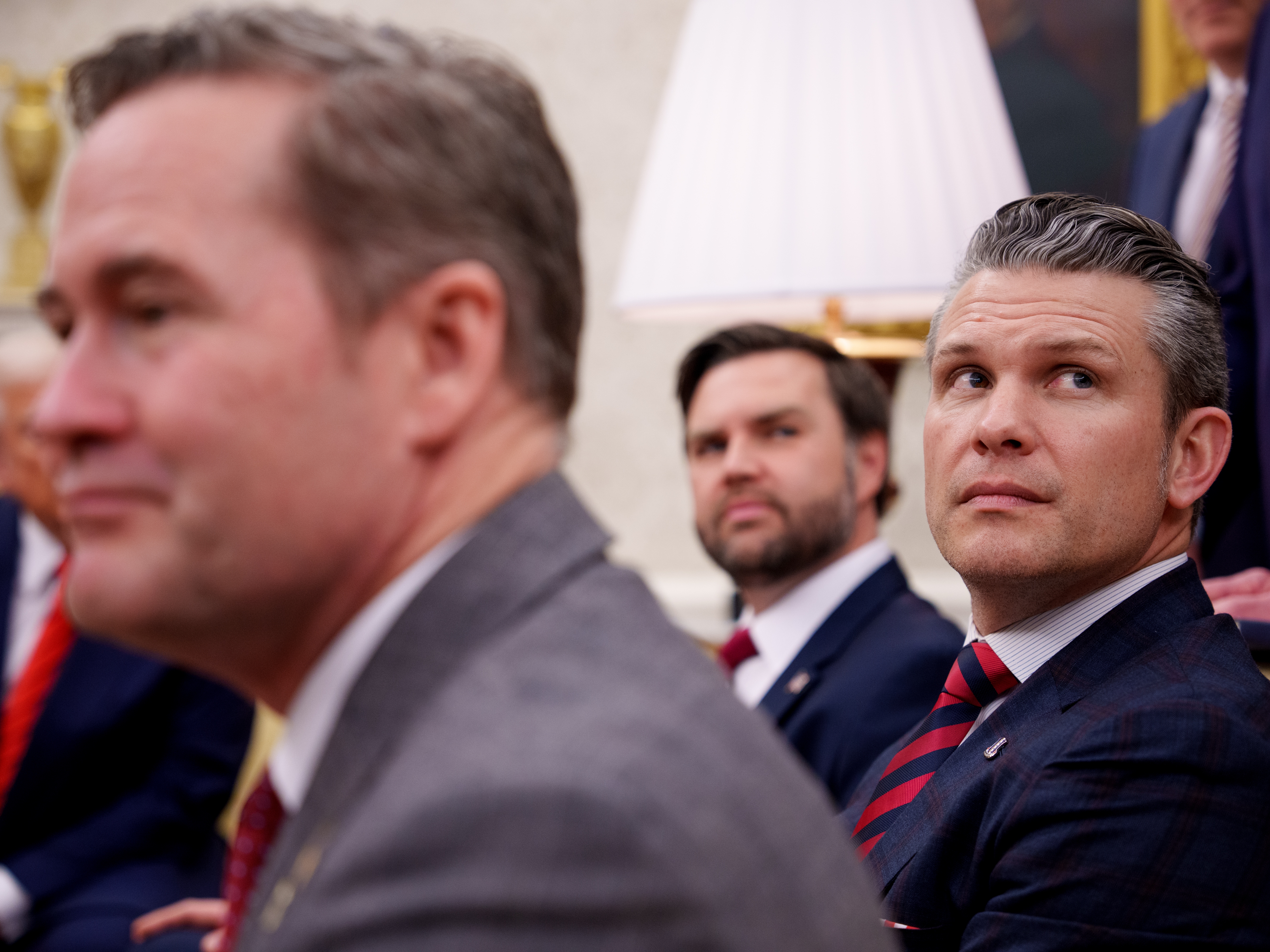 caption: President Trump, National Security Adviser Michael Waltz, Vice President Vance and Defense Secretary Pete Hegseth listen to a question from a reporter during a meeting in the Oval Office on March 13.