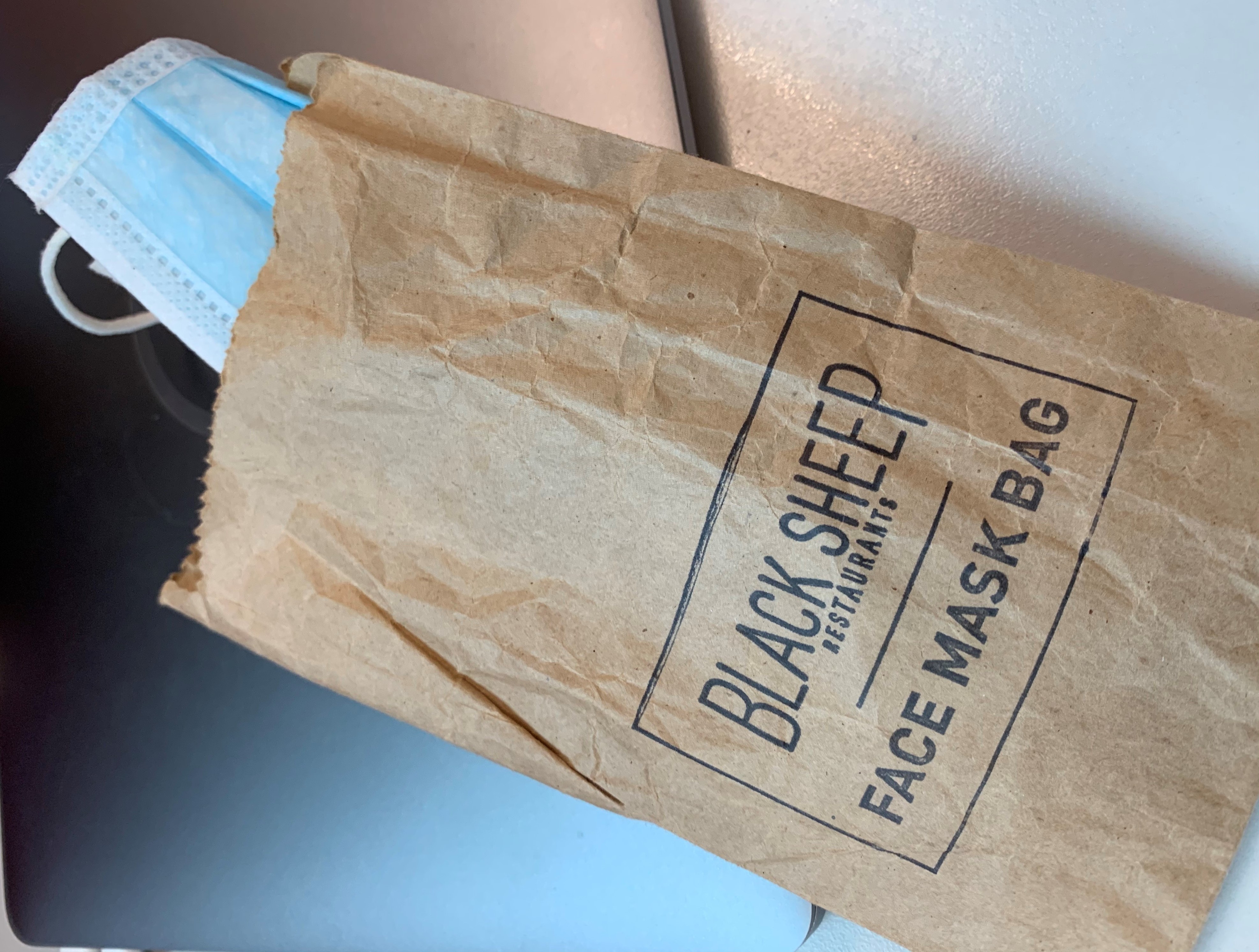 caption: Some restaurants in Hong Kong provide diners a pouch for face masks.