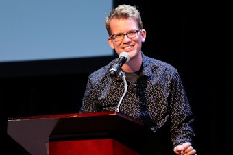 caption: YouTube personality and author Hank Green speaks on stage as he discusses his new book, <em>An Absolutely Remarkable Thing</em> in New York City on Sept. 25, 2018.