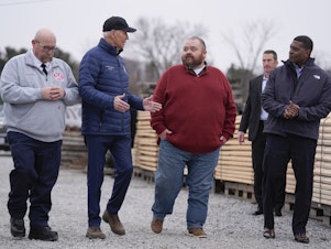 caption: President Biden talks with East Palestine, Ohio Mayor Trent Conaway during a tour of the site where a train carrying toxic chemicals derailed a year ago.