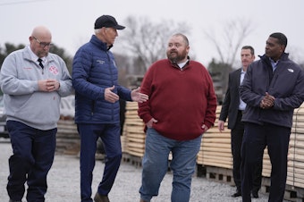 caption: President Biden talks with East Palestine, Ohio Mayor Trent Conaway during a tour of the site where a train carrying toxic chemicals derailed a year ago.