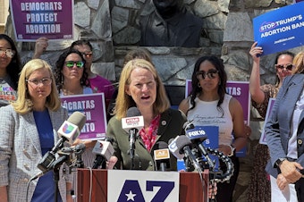 caption: Arizona's Democratic Attorney General Kris Mayes, speaking in Phoenix last month after the state's supreme court ruled that an 1864 ban on abortion could be enforced, had pledged not to enforce the law. Now the legislature has voted to repeal it.