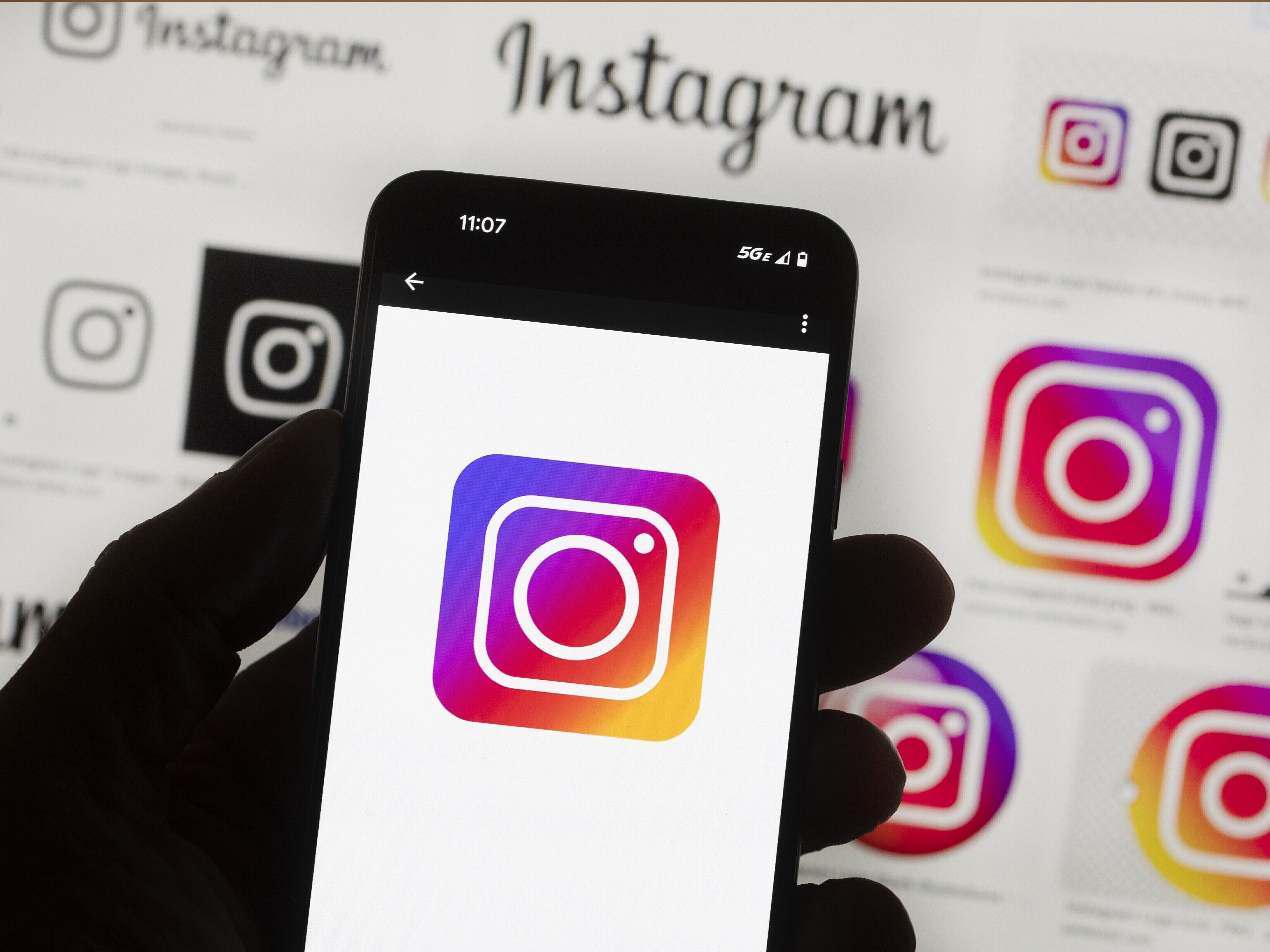 caption: The Instagram logo is seen on a cellphone.