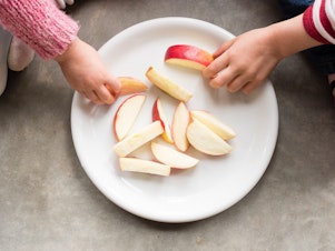 caption: Children share apples in Sydney, Australia.