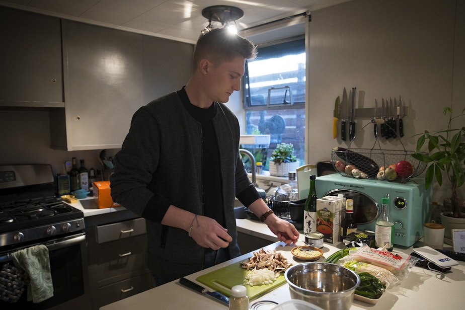 caption: Biggest Carbon Loser Will Wilson cooks a low-carbon meal at his apartment in February in Seattle. 