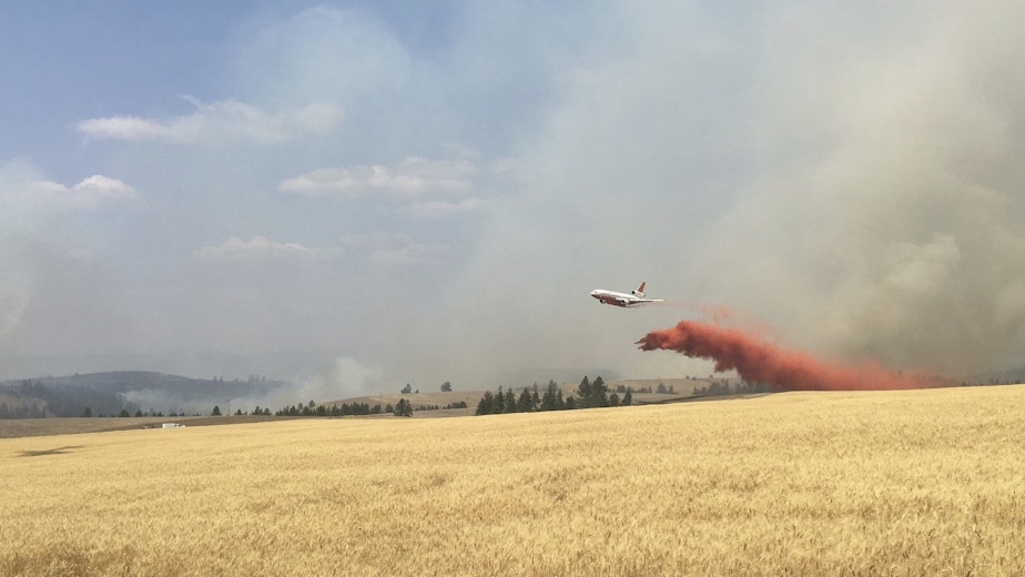 caption: In this photo released by The Eastern Area Incident Management Team, a Very Large Air Tanker (VLAT) drops retardant on a wheat field as crews continue to battle a wildfire in eastern Washington state Sunday, Aug. 5, 2018. 