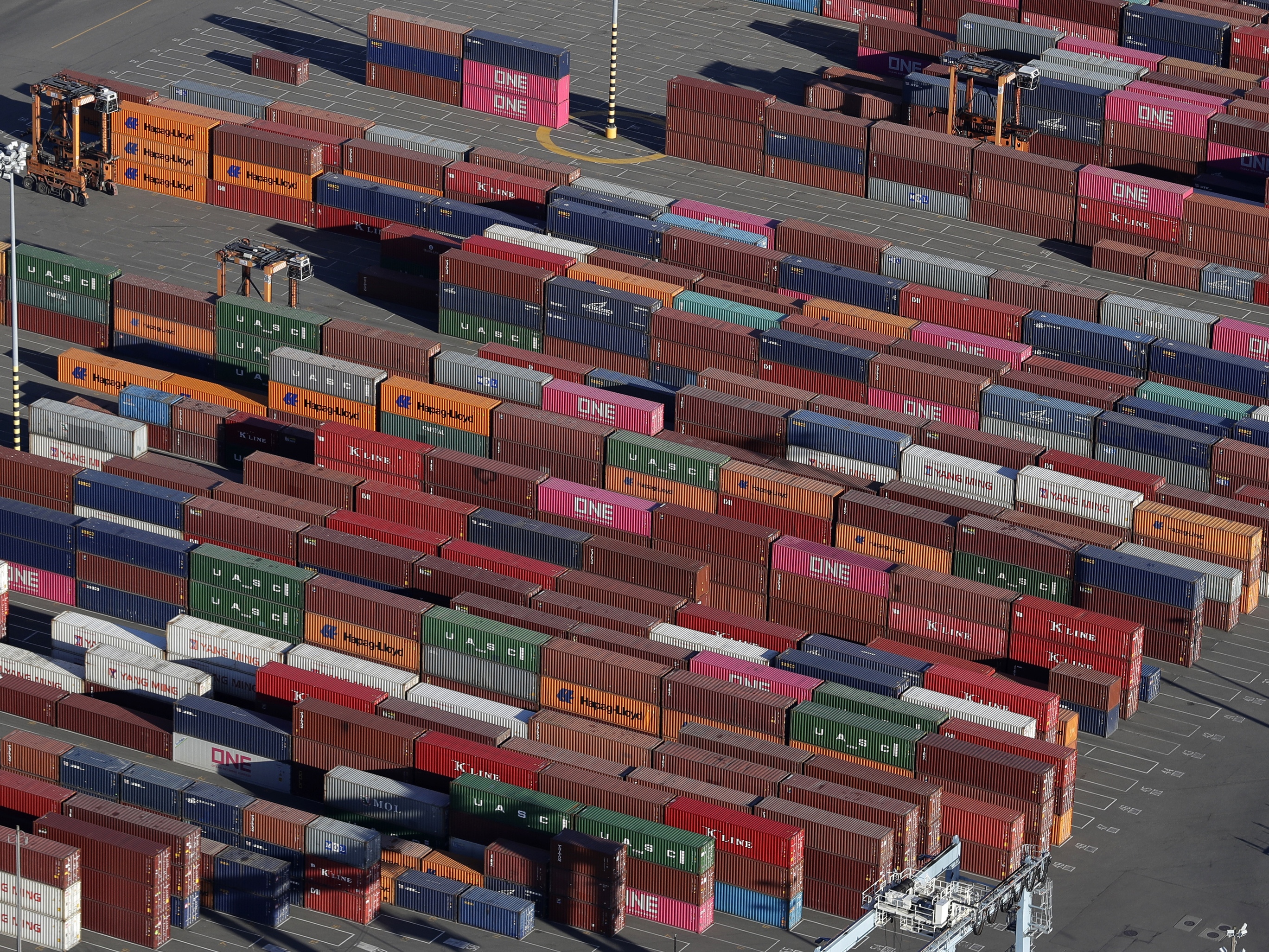 caption: Cargo containers are staged near cranes at the Port of Tacoma in Washington.