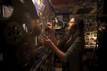 caption: Sarah Kleehamer, a volunteer projectionist, removes a reel from the wall on Tuesday, June 12, 2018, at Grand Illusion Cinema in Seattle. Kleehammer has been volunteering at the cinema for 15 years. 