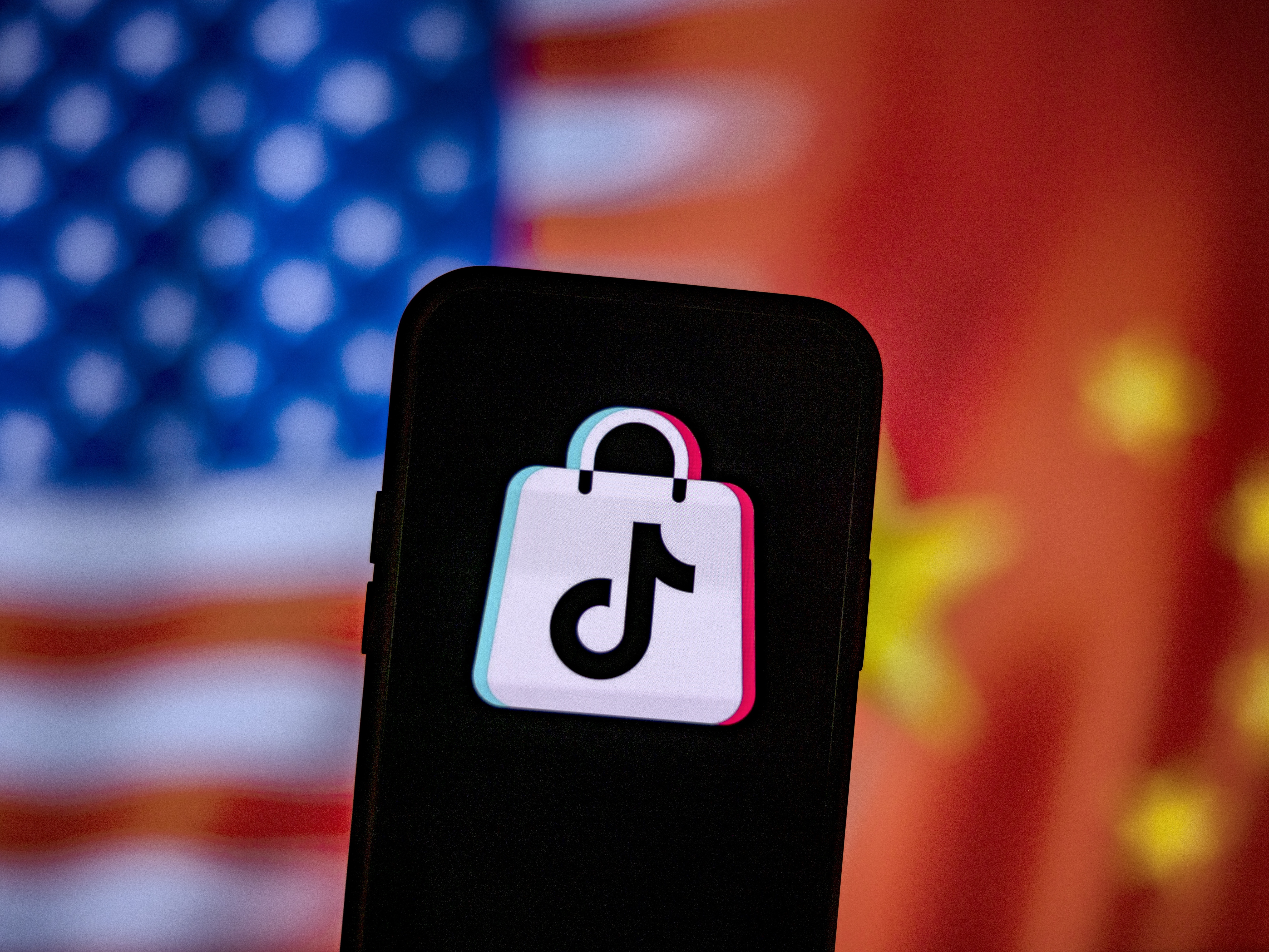 caption: A photo illustration of the TikTok logo next to U.S. and China flags. Researchers have uncovered more accounts tied to a Chinese influence operation known as "Spamoflauge" which includes an account on TikTok with one video that managed to get 1.5 million views before being taken down.