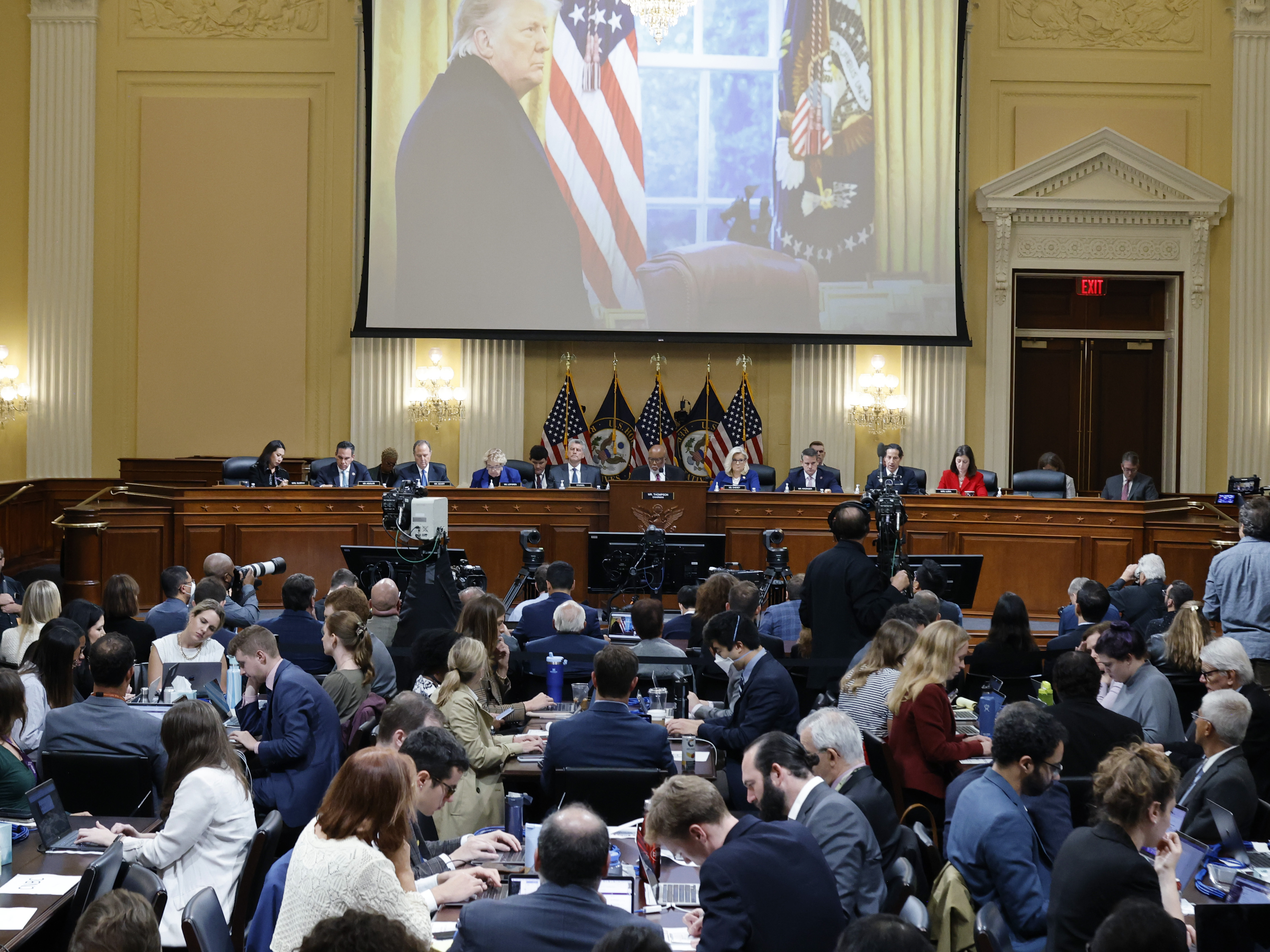 caption: A photo of then-President Donald Trump speaking is displayed as the House select committee investigating the Jan. 6 attack on the Capitol holds a hearing on on Oct. 13.