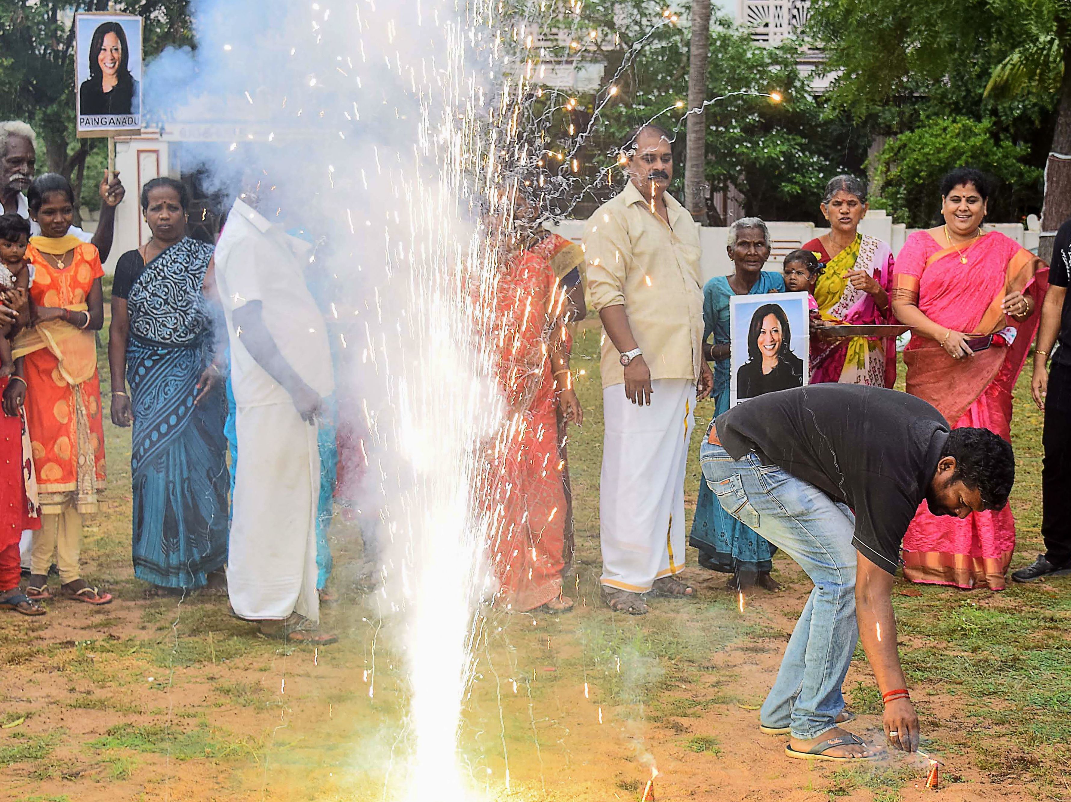 caption: Residents hold placards with the portrait of of Vice President-elect Kamala Harris, as they celebrate her election victory in her ancestral village of Thulasendrapuram in the southern Indian state of Tamil Nadu on Saturday.