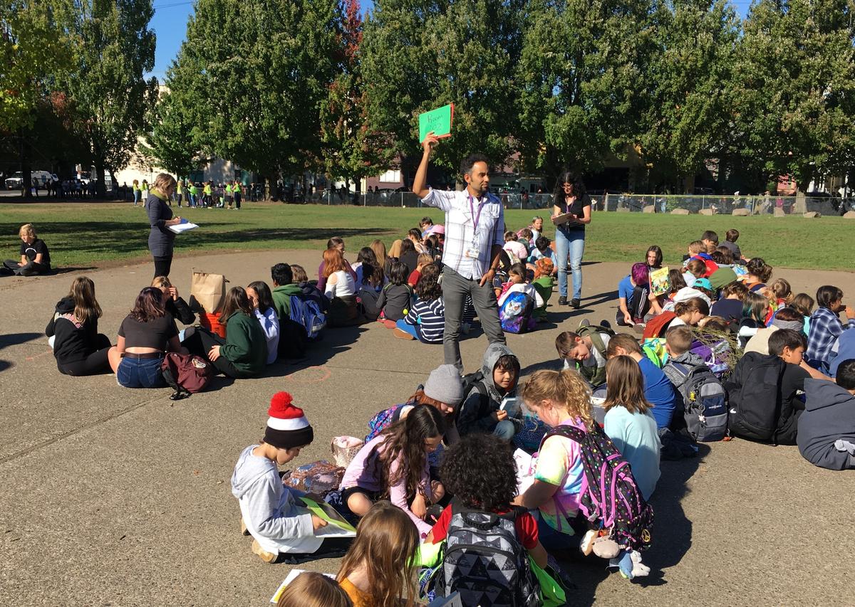 caption: Teacher Jeremy Thomas holds up an all-accounted-for sign after the school evacuation.CREDIT: TOM BANSE / N3