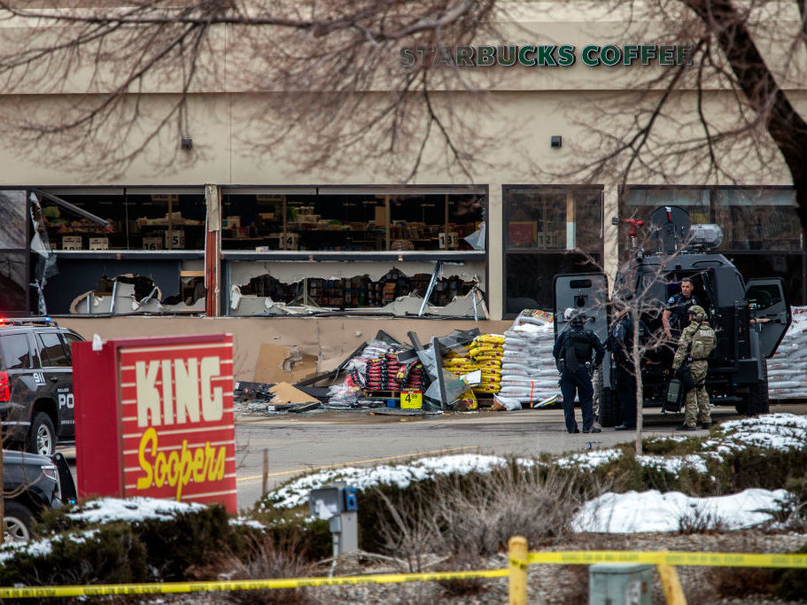 caption: Tactical police units respond to the scene of a King Soopers grocery store after a shooting on March 22, 2021 in Boulder, Colorado.