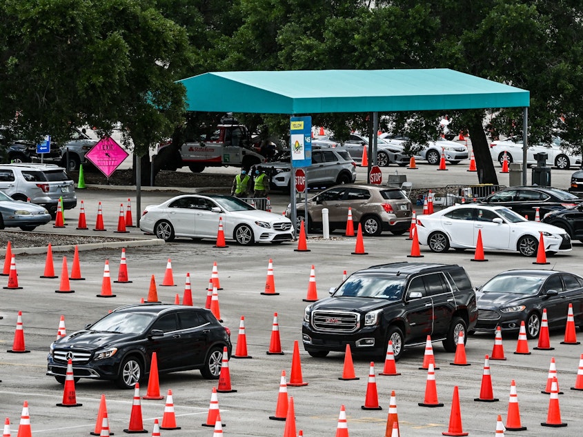 caption: People wait in their vehicles to get vaccinated last week at a drive-through site at Hard Rock Stadium in Miami Gardens, Fla. President Biden Tuesday announced an April 19 deadline for all states to open eligibility to individuals ages 18 and up.