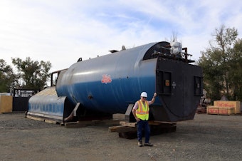 caption: Biomass Operations Specialist John Rowell stands next to a boiler that awaits installation pending permits.CREDIT: TOM BANSE / N3