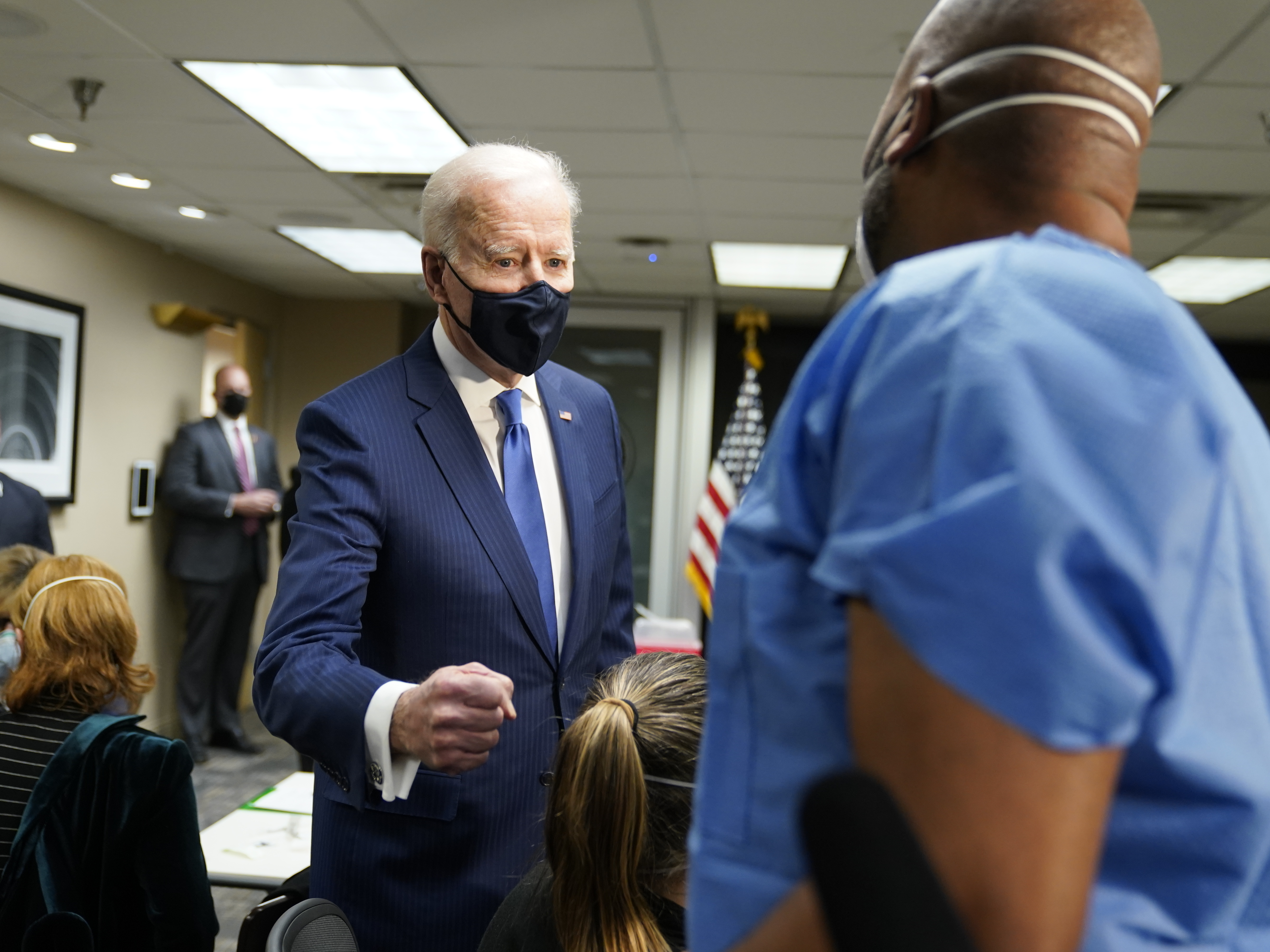 caption: President Biden talks to recently vaccinated Army Staff Sgt. Marvin Cornish as he visits a COVID-19 vaccination site at the VA Medical Center in Washington, D.C., on Monday.