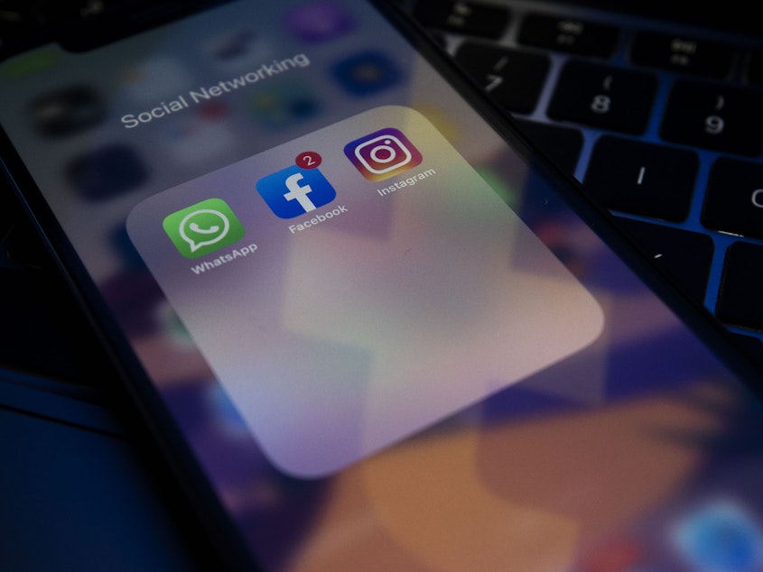 caption: A photo illustration shows social media apps Instagram, Facebook and WhatsApp on a phone screen. Facebook says its worldwide services were taken offline by a problem with its servers.