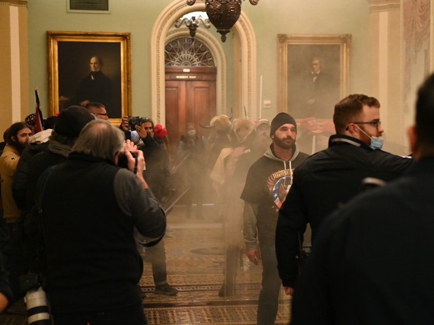 caption: Supporters of U.S. President Donald Trump storm the U.S. Capitol as smoke fills the corridor on January 6, 2021, in Washington, DC.