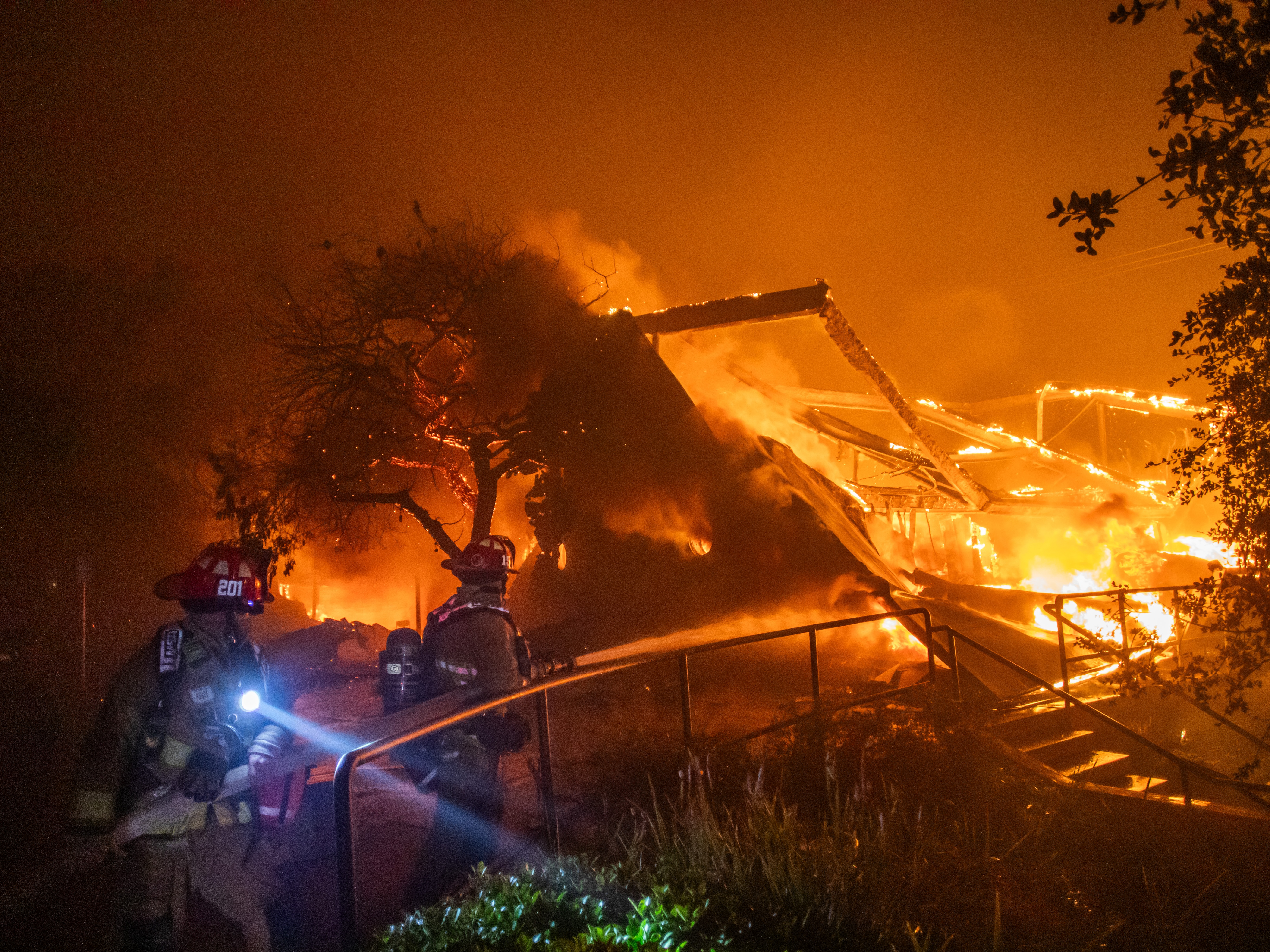 caption: Firefighters battle flames from the Palisades fire burning the Theatre Palisades during a powerful windstorm on Wednesday in the Pacific Palisades neighborhood of Los Angeles.