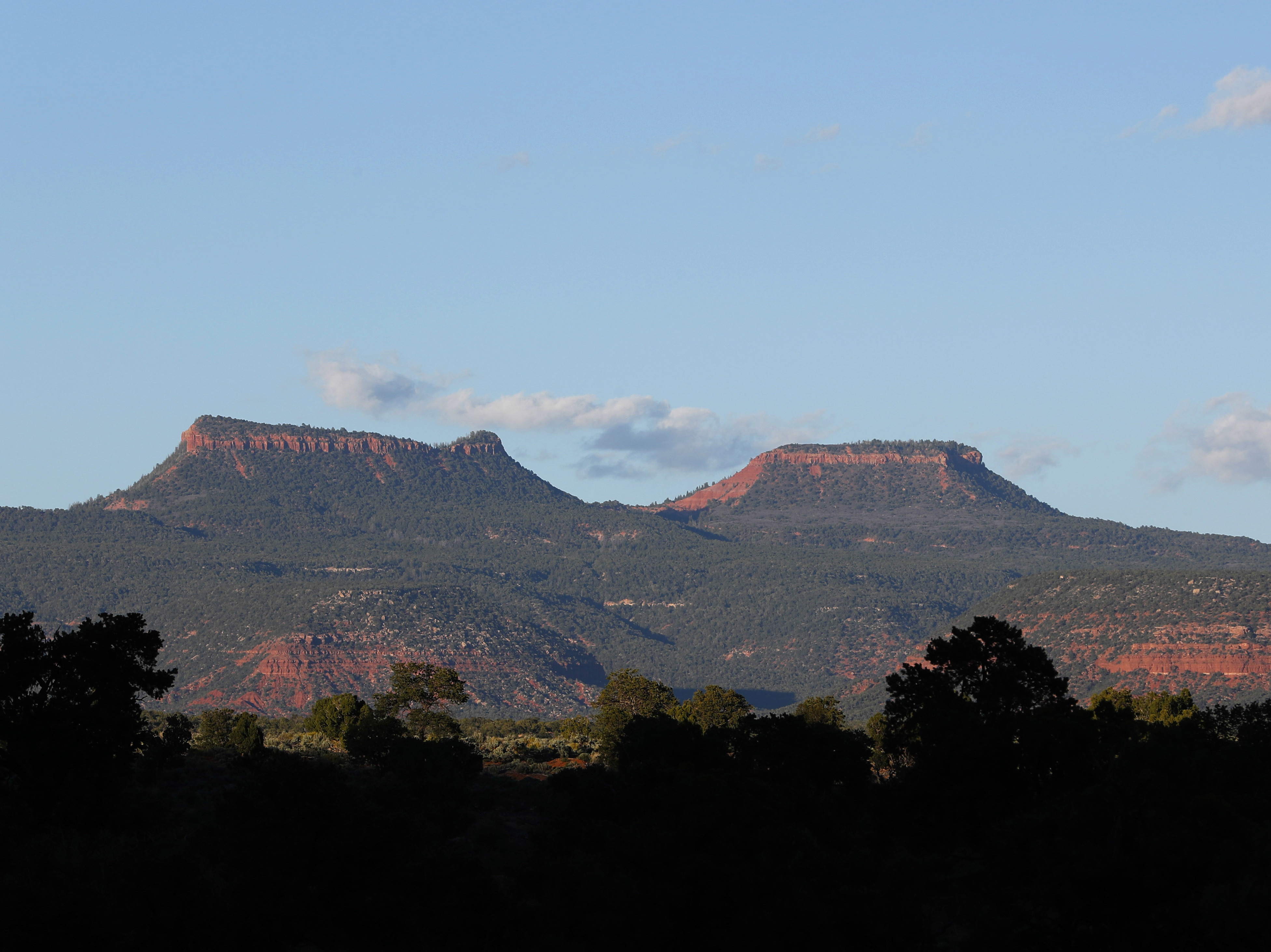 caption: The two bluffs that inspired the name of the Bears Ears National Monument, seen at sunset outside Blanding, Utah. On Thursday, more than two years after the Trump administration announced plans to shrink the monument and others, federal managers have finalized the new land use plans.