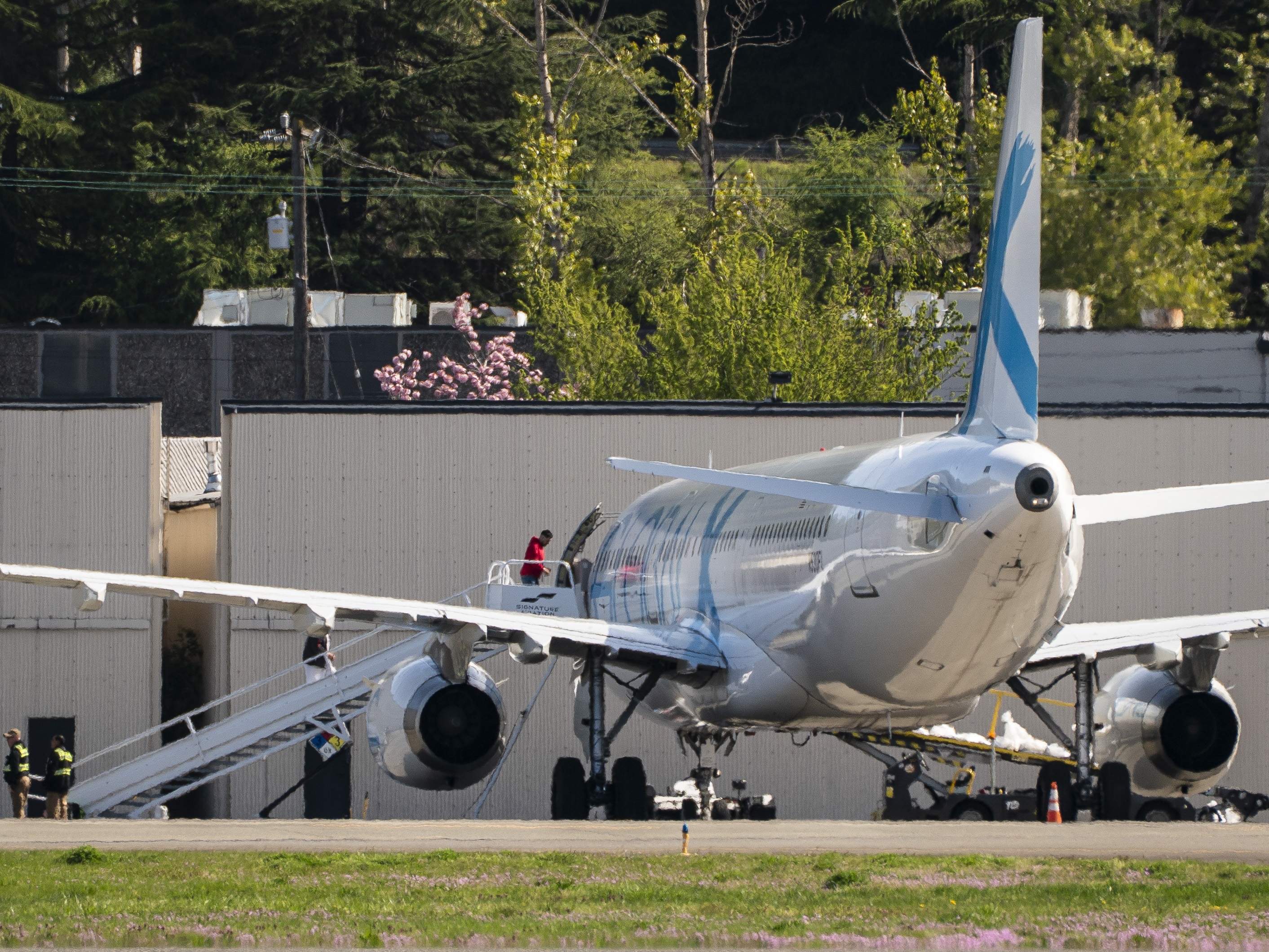 caption: Detainees board a plane chartered by U.S. Immigration and Customs Enforcement (ICE) at King County International Airport on April 15, 2025 in Seattle, Washington. Semi-regular flights carrying detainees pass through the airport as the Trump administration continues to plan for the expansion of immigrant detention and deportation.