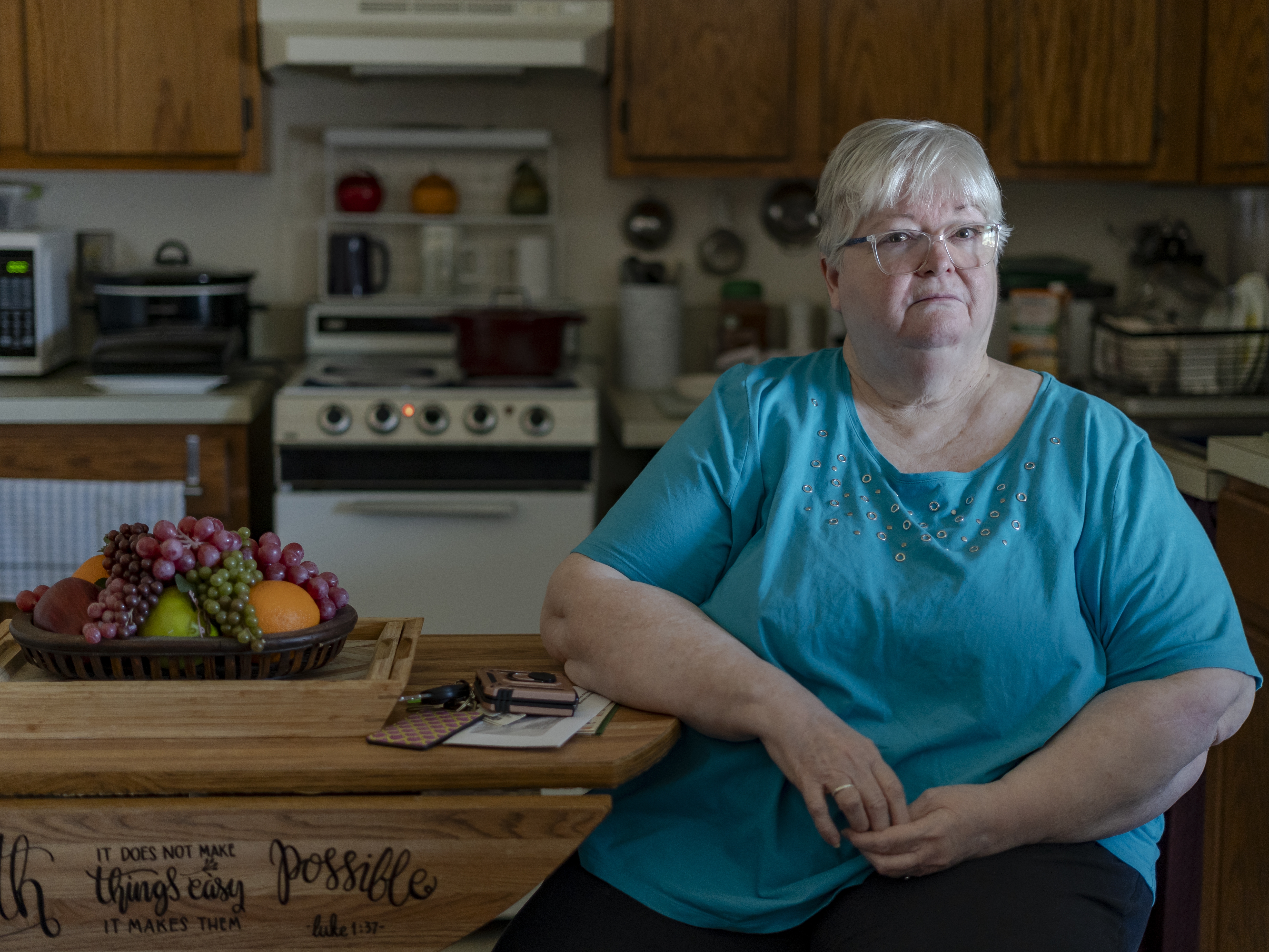 caption: Linda Morgan on March 28 in her sister's apartment at Trinity Woods senior living in Emporia, Va., where they both live. The building's decades-old central air conditioning system died three years ago. "It's terribly hot," said Morgan, who uses six fans and portable coolers to stay comfortable during long summers.