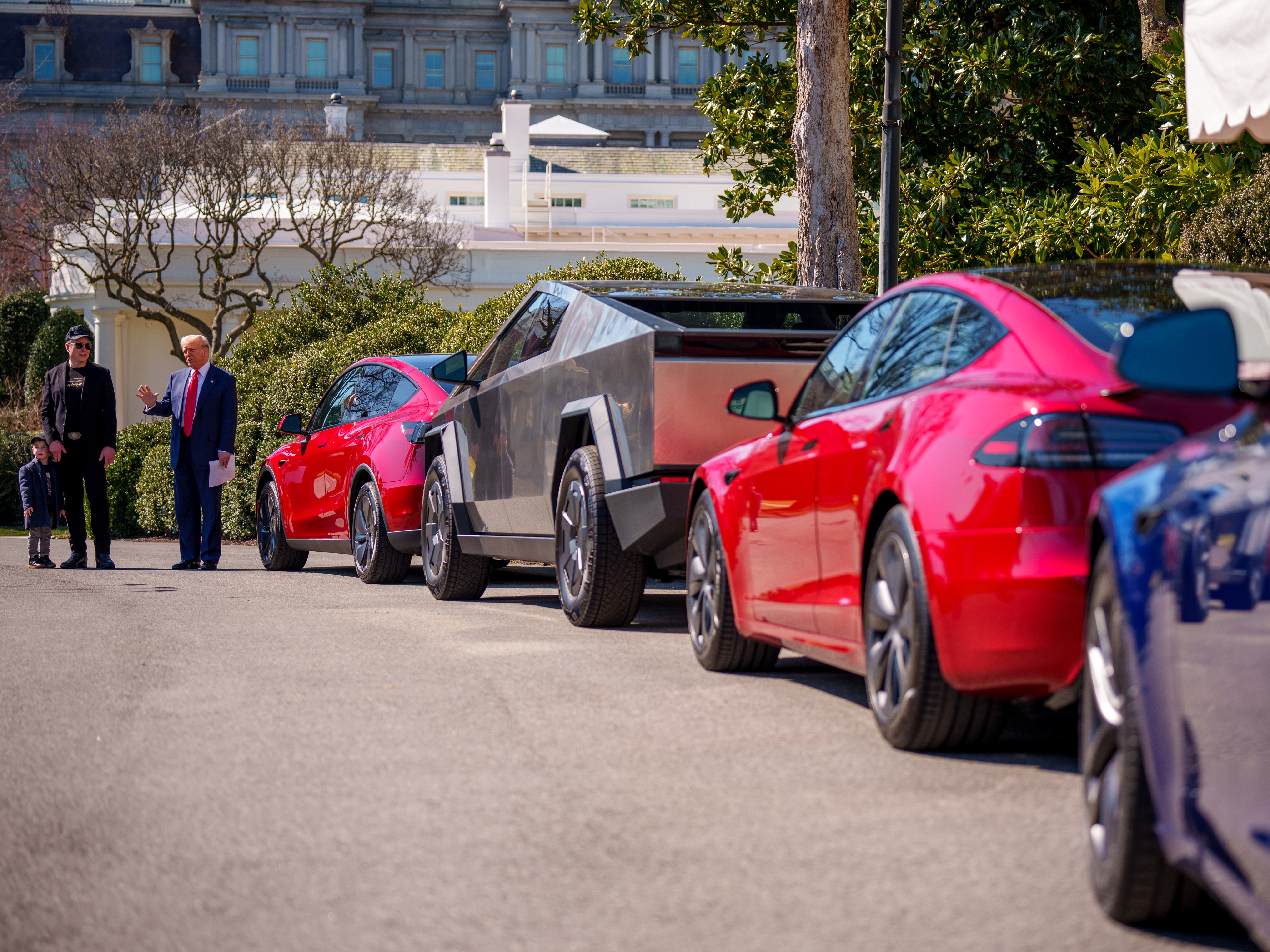 caption: President Trump, accompanied by Tesla CEO Elon Musk and his son X Æ A-Xii, speaks next to a line of Tesla vehicles on the South Lawn of the White House on Tuesday. Trump said he would purchase a Tesla vehicle in what he calls a 'show of confidence and support' for Musk. But while Musk is very popular among Republicans, Democrats remain more interested in purchasing electric vehicles.