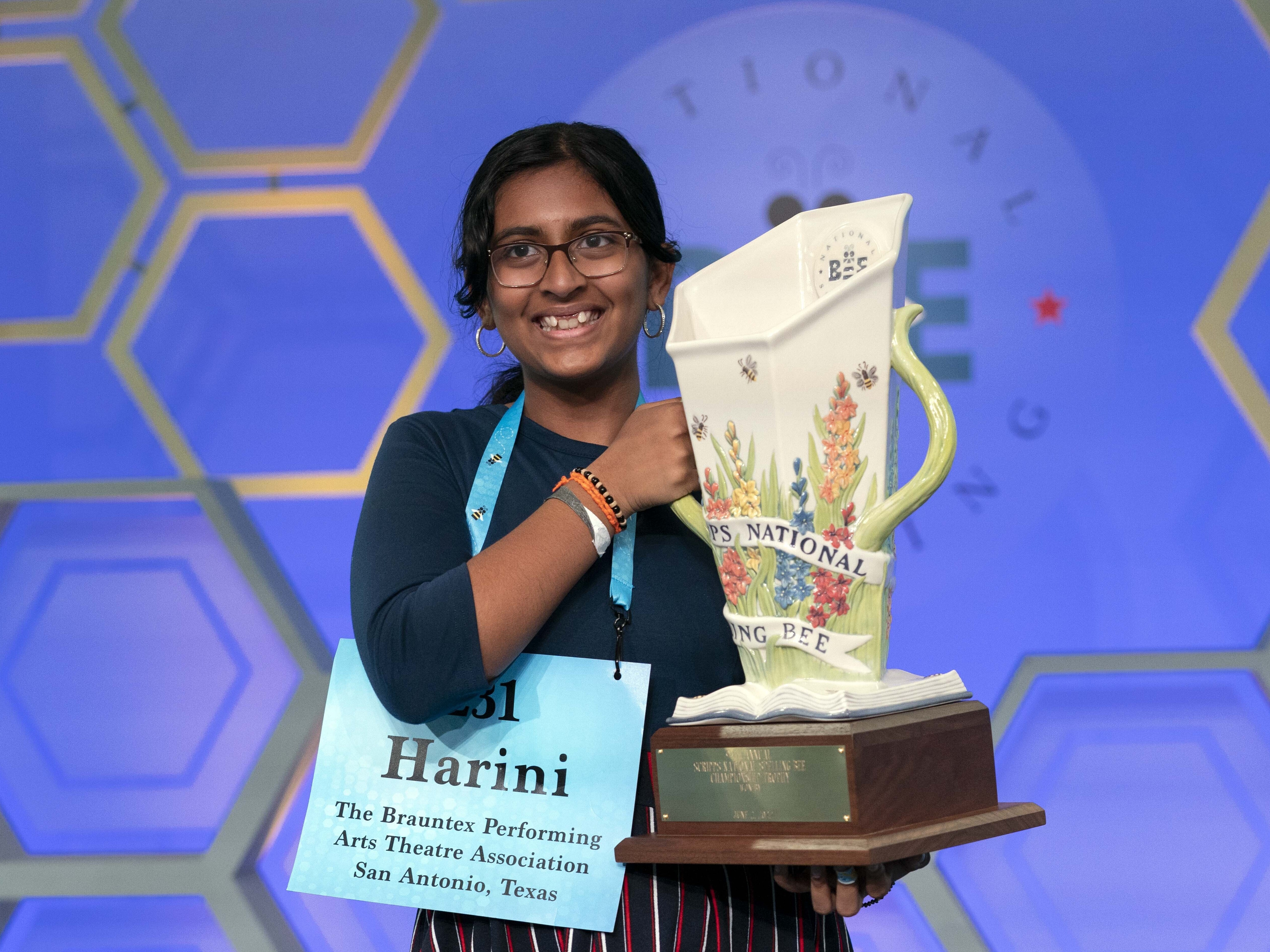 caption: Harini Logan, 14, from San Antonio, Texas, holds her winning Scripps National Spelling Bee trophy, Thursday, June 2, 2022, in Oxon Hill, Md.