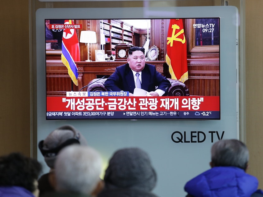 caption: People at a railway station in Seoul, South Korea, watch a TV screen showing North Korean leader Kim Jong Un delivering his New Year's speech on Tuesday.