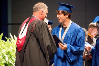 caption: Matanzas High School Principal Jeff Reaves shakes a student's hand on graduation day. Reaves handwrote 459 notes to the graduating class of 2021 to celebrate their accomplishments.