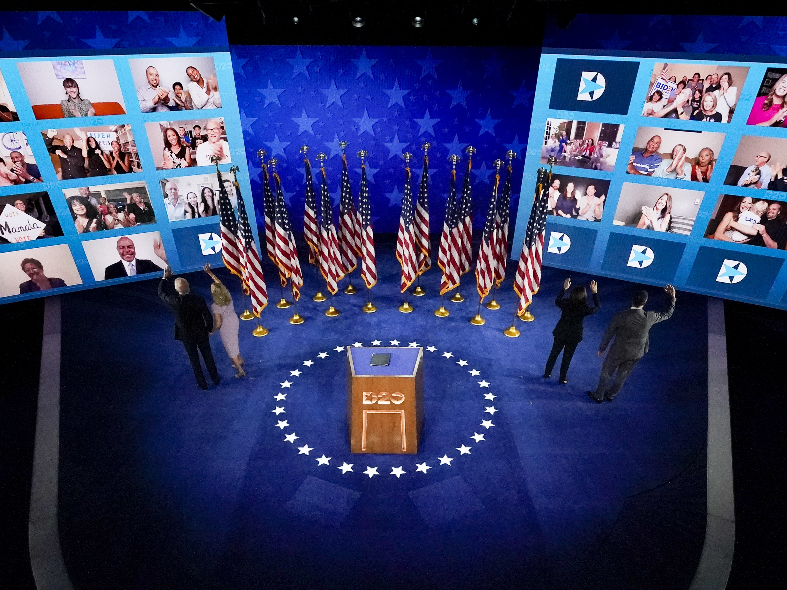 caption: From left, on stage, Joe Biden, Jill Biden, Kamala Harris,and Doug Emhoff , wave to supporters connected virtually after Biden spoke Thursday night.