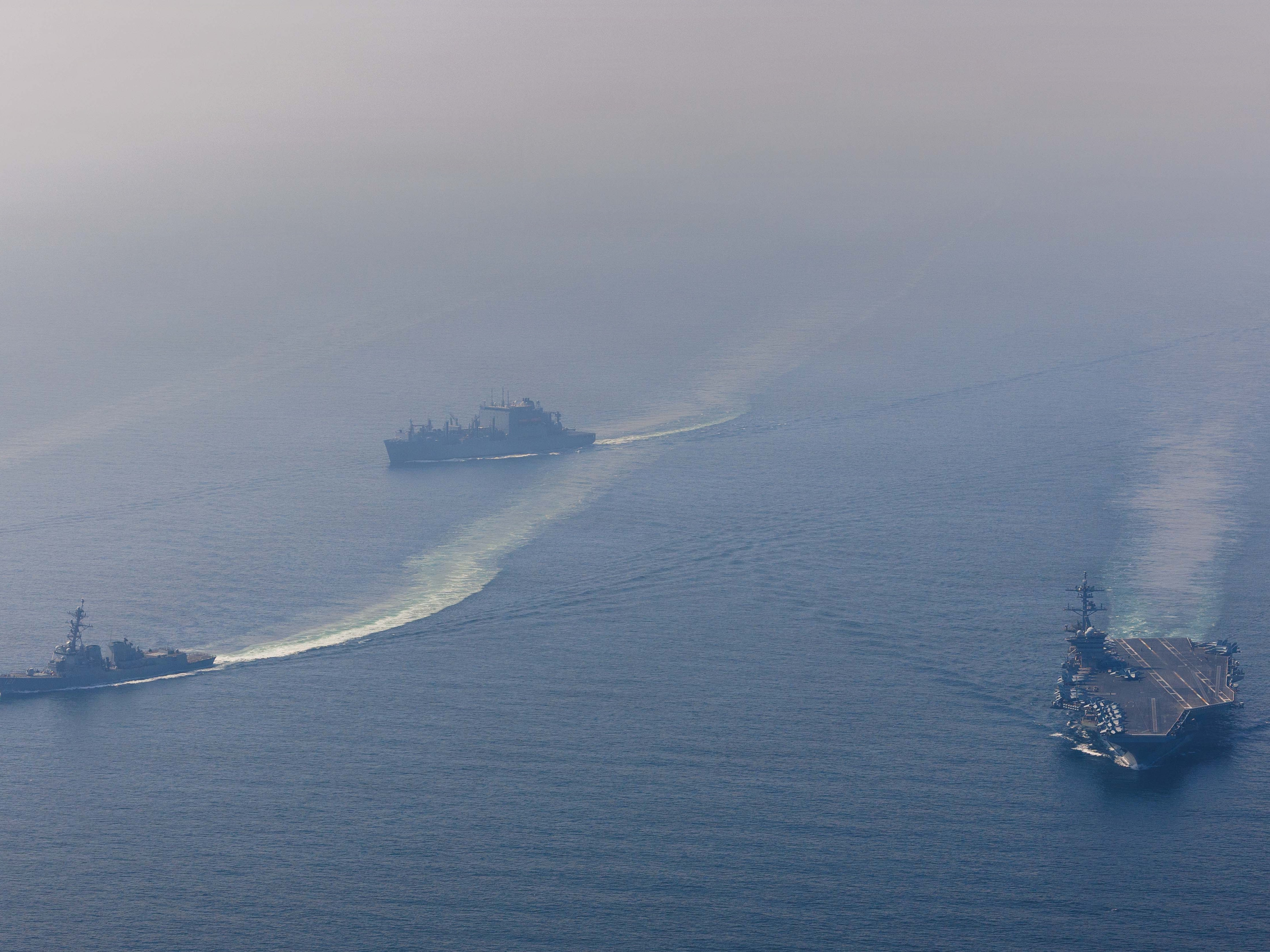 caption: The U.S. Navy's aircraft carrier USS Abraham Lincoln sails alongside guided-missile destroyer USS Frank E. Petersen Jr. and dry cargo ship USNS Carl Brashear in the Arabian Sea on Feb. 6.