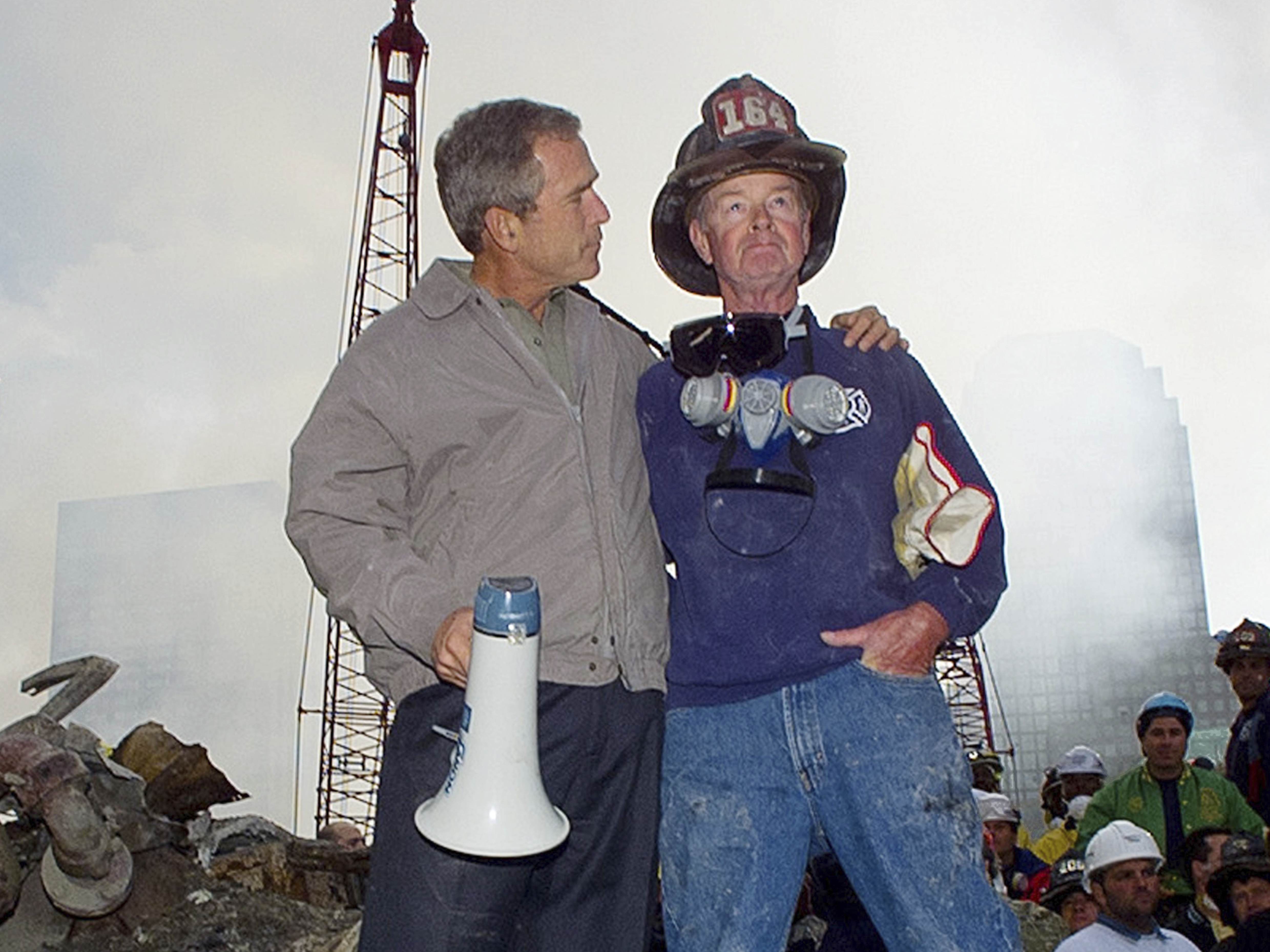 caption: Then-President George W. Bush is shown with New York City firefighter Bob Beckwith on a burnt fire truck in front of the World Trade Center during a tour of the devastation, Sept. 13, 2001.