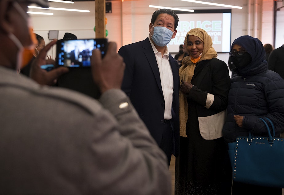 caption: Bruce Harrell poses for a photograph with supporters Nafiso Samatar and Hawa Egal, right, during an election night party for Harrell on Tuesday, November 2, 2021, at Block 41 on Bell Street in Seattle. 