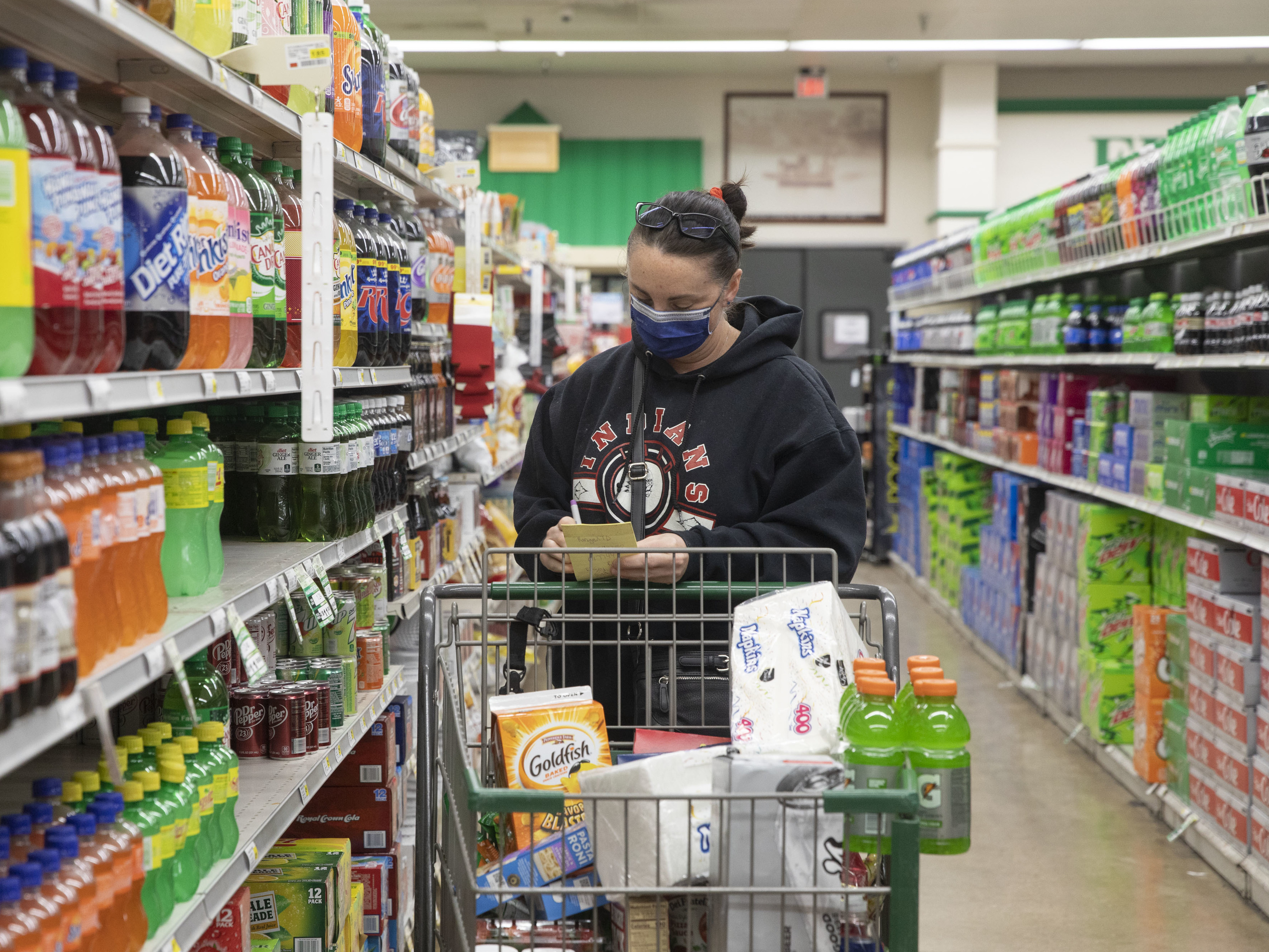 caption: The CDC's new guidelines on face coverings and social distancing are raising questions about grocery store requirements moving forward.
