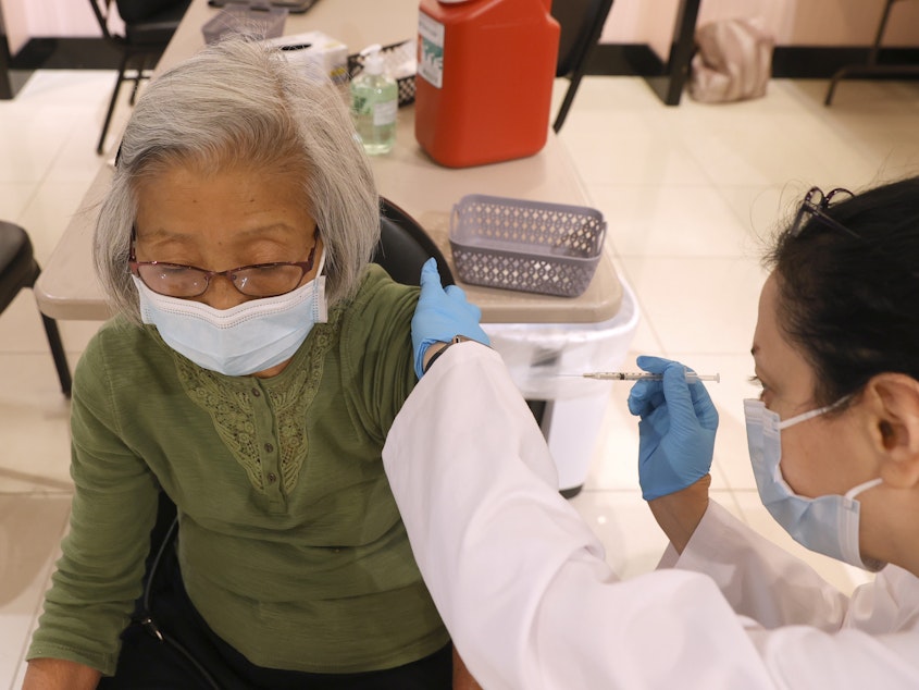 caption: Safeway pharmacist Shahrzad Khoobyari administers a Pfizer-BioNTech COVID-19 booster shot to Chen Knifsend at a vaccination clinic in San Rafael, Calif., in October. The companies are seeking regulatory authorization to expand boosters to everyone 18 and older.