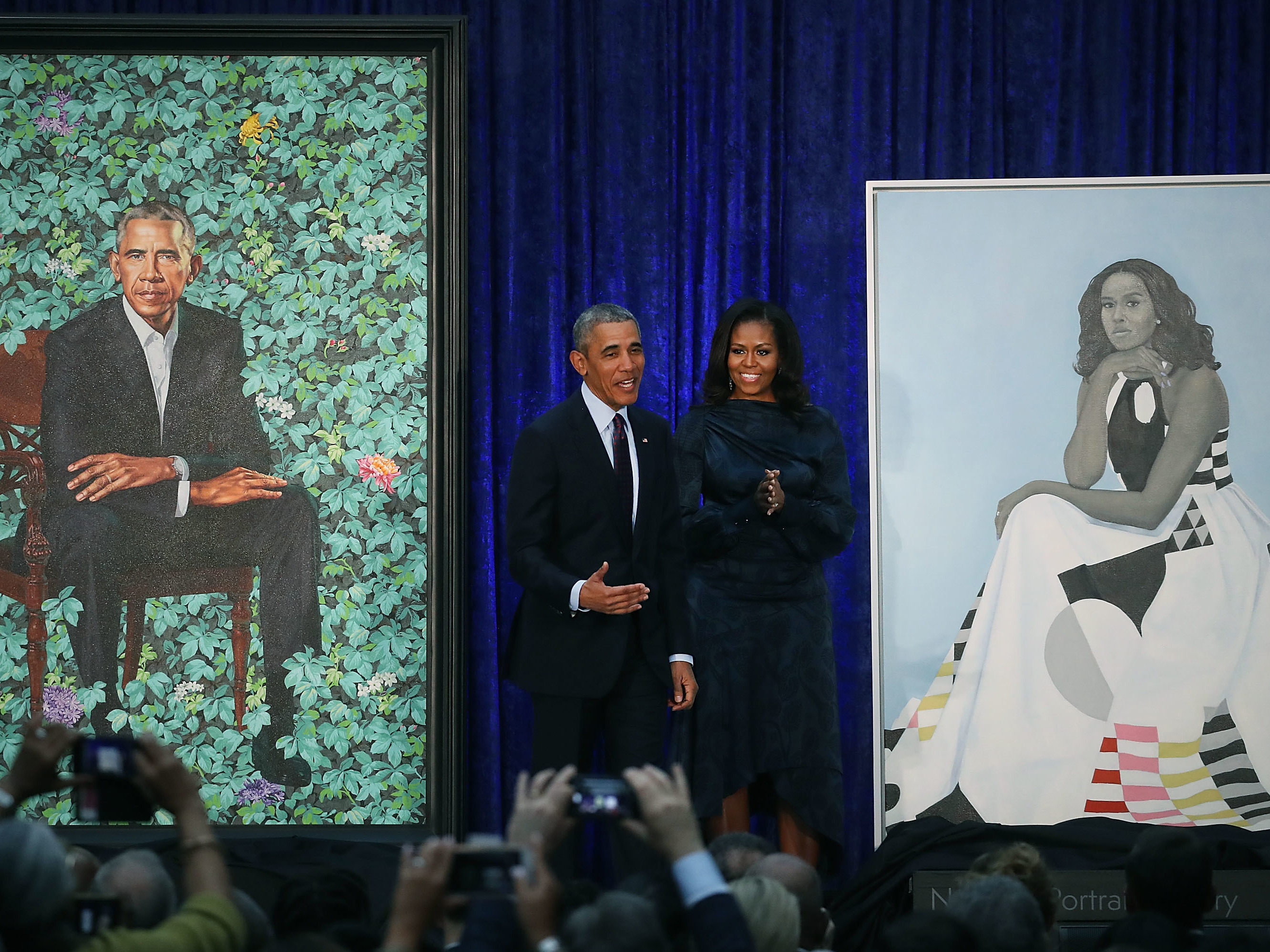caption: Former President Barack Obama and former first lady Michelle Obama stand next to their newly unveiled portraits during a ceremony at the Smithsonian's National Portrait Gallery on Feb. 12, 2018. The portraits are set to go on a yearlong tour to five cities in June of 2021.