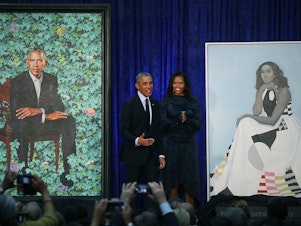 caption: Former President Barack Obama and former first lady Michelle Obama stand next to their newly unveiled portraits during a ceremony at the Smithsonian's National Portrait Gallery on Feb. 12, 2018. The portraits are set to go on a yearlong tour to five cities in June of 2021.