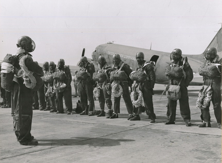 caption: Paratroopers at Pendleton Army Airfield getting briefed before taking off to drop on a wildfire in the summer of 1945.
