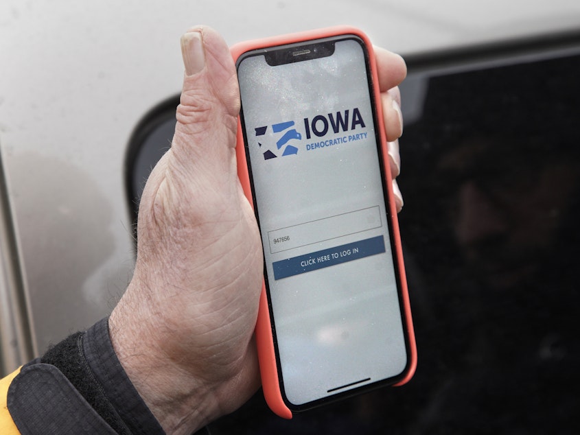 caption: A precinct captain displays the Iowa Democratic Party caucus reporting app on his phone on Feb. 4, 2020. The app's technical difficulties marred Democrats' 2020 Iowa caucuses.