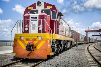 caption: China's New Silk Road project is lending out billions to countries in Central Asia, the Middle East and Africa to build and upgrade railways, ports, pipelines, power grids and highways. Above: A Kenya Railways train pulls shipping containers as it departs from the Mombasa port station.