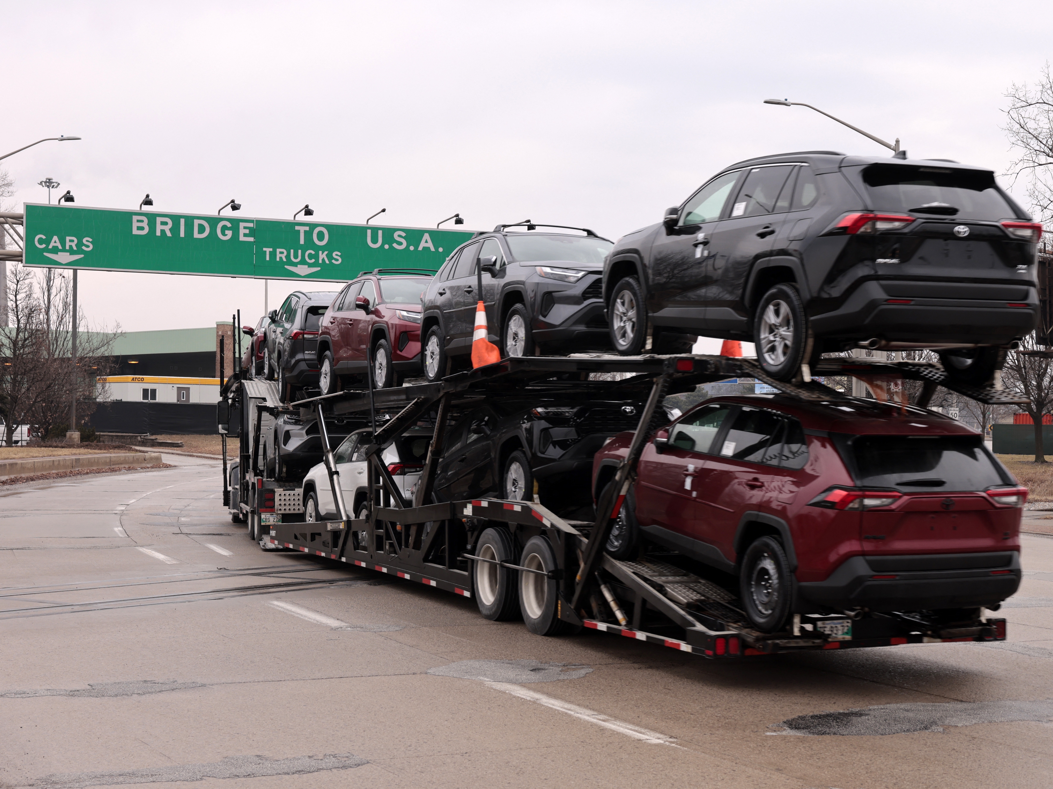 caption: A car hauler carries Toyota RAV4 vehicles as it enters to cross the Ambassador Bridge in Windsor, Ontario to go to Detroit, Michigan on February 3.