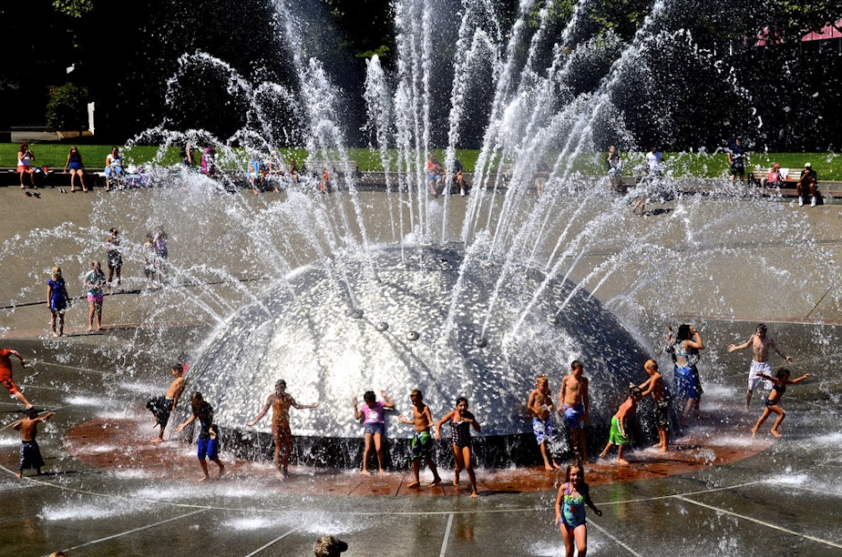 caption: People cool off in Seattle Center's International Fountain.