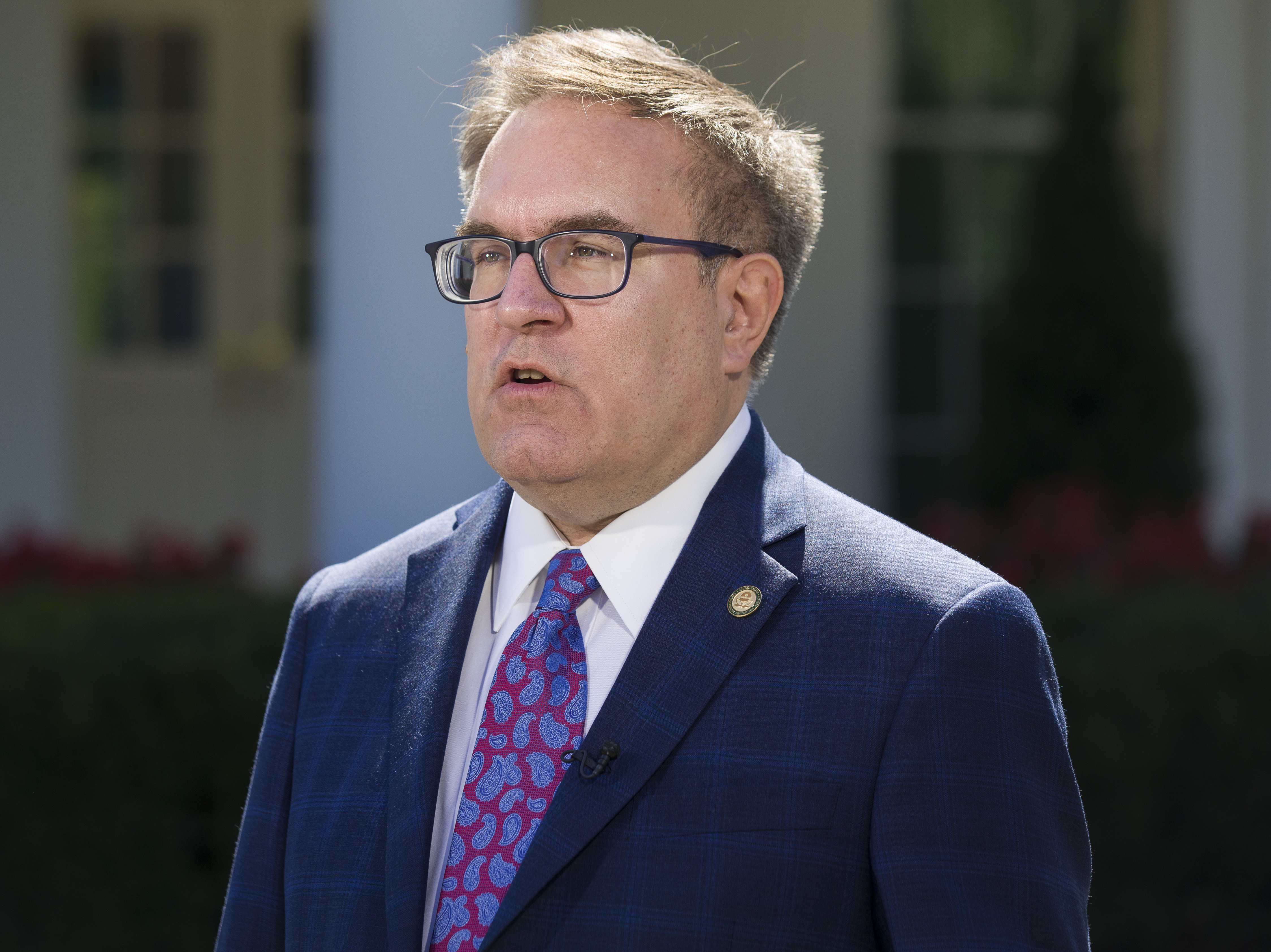 caption: Environmental Protection Agency administrator Andrew Wheeler speaks during a television interview in front of the West Wing of the White House, on Sept. 19, 2019. Wheeler has threatened to withdraw billions of dollars in federal highway money unless California clears a backlog of air pollution control plans.