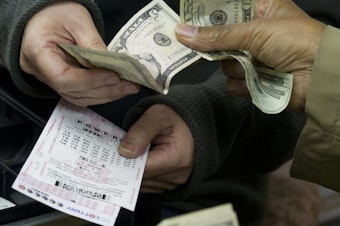 caption: A customer purchases Powerball lottery tickets in Washington in 2012. The Maryland Lottery says a retired utility worker has won a $2 million prize for the second time since 2018.