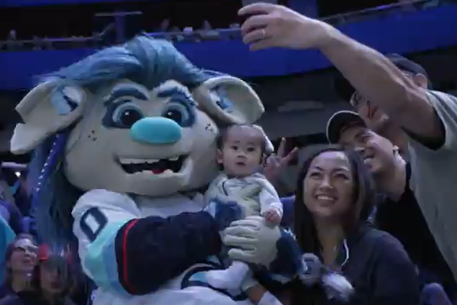 caption: Seattle Kraken's Buoy poses with fans shortly after the mascot made its first appearance ever on the ice. 