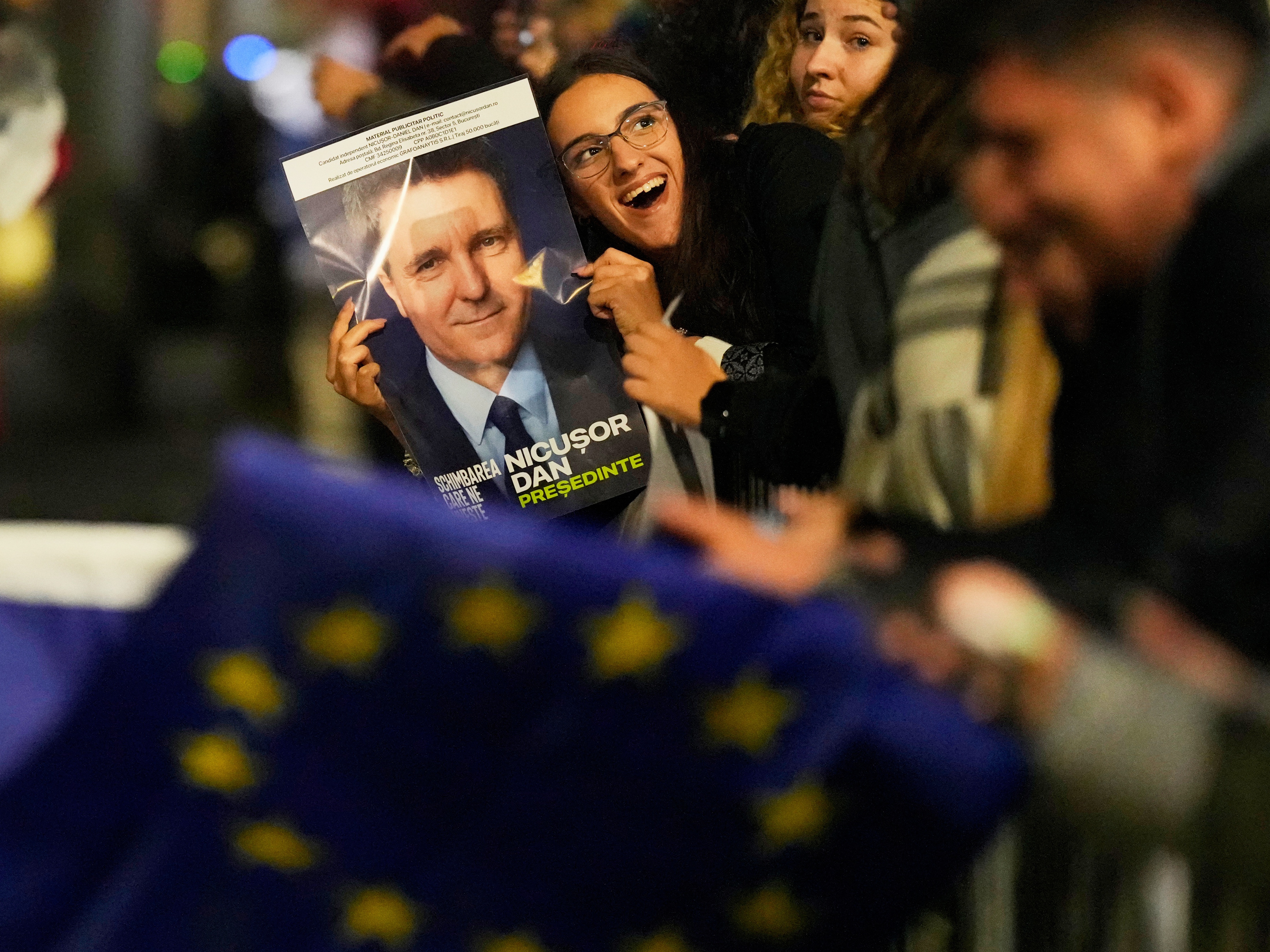 caption: Supporters of presidential candidate Nicusor Dan celebrate on the street after polls closed for the second round of the country's presidential election redo in Bucharest, Romania on Sunday.