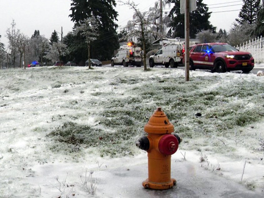 caption: In this image made from a video provided by KGW, authorities work the scene Wednesday, Jan. 17, 2024, in Portland, Ore, after a power line fell on a vehicle, killing three people and injuring a baby during an ice storm that turned roads and mountain highways treacherous in the Pacific Northwest.